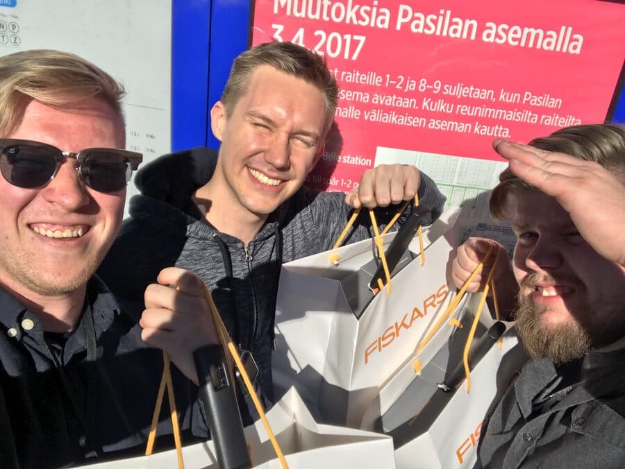 Perttu taking a selfie with teammates holding Fiskars gift bags