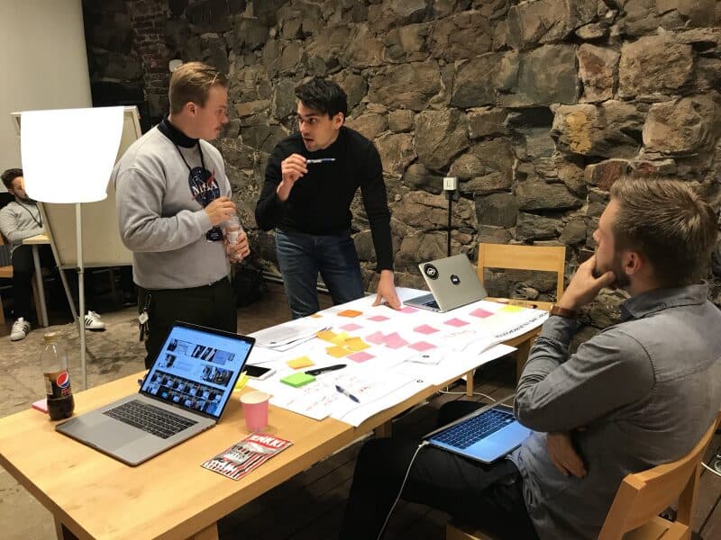 Perttu and teammates working around a table of sticky notes at Kuohu